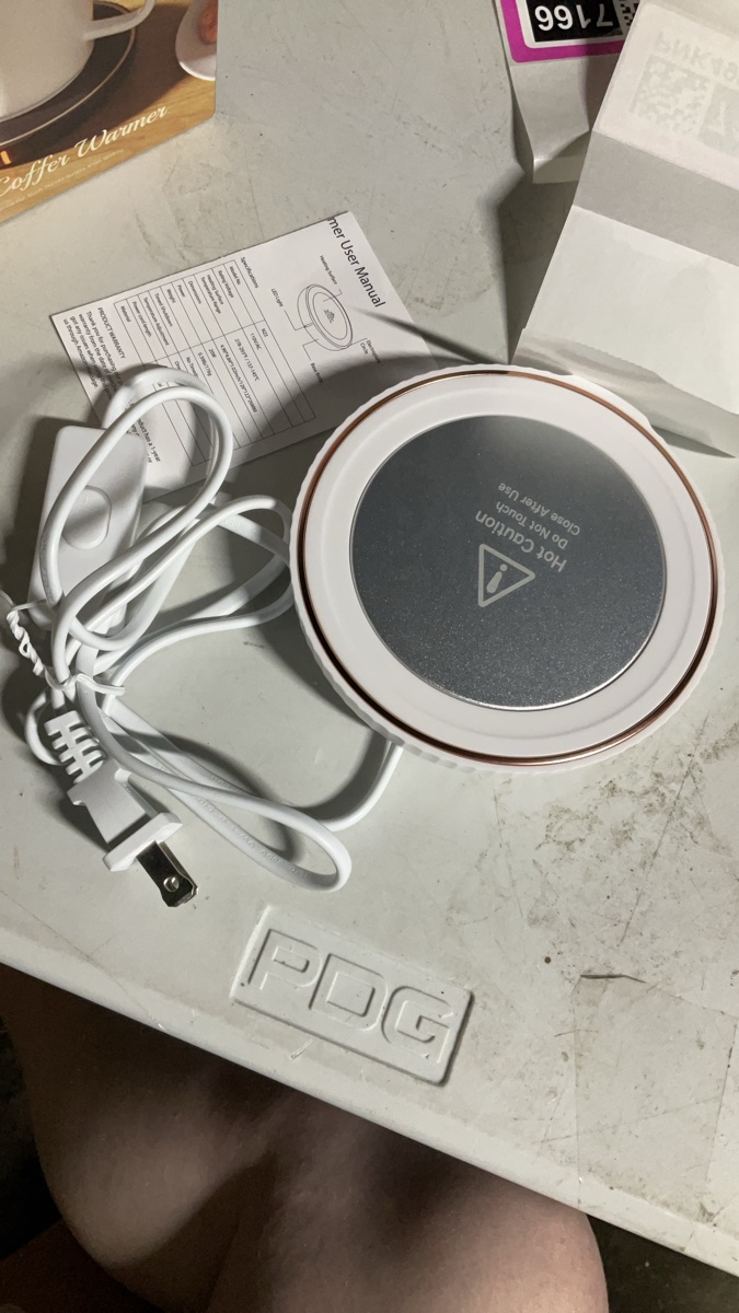 White Electric Coffee Mug Warmer Featuring A Flat Metallic Heating Plate And A Standard Two Prong Power Plug